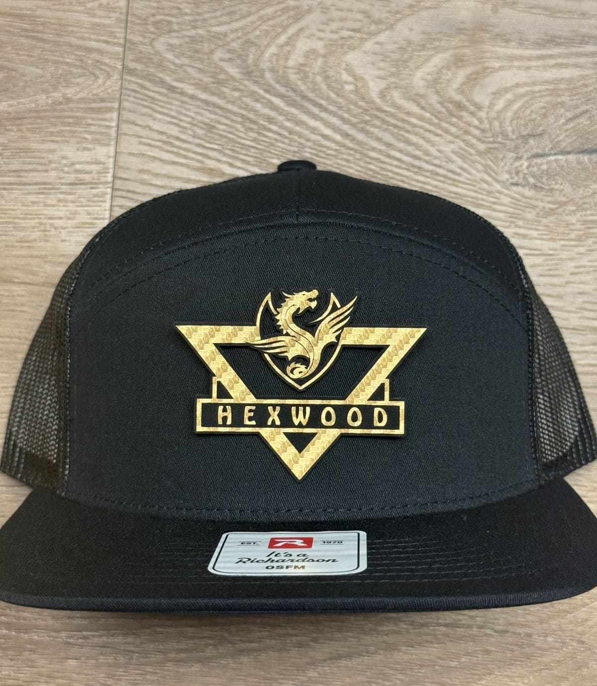 Black Hexwood Creations hat with a gold crest design